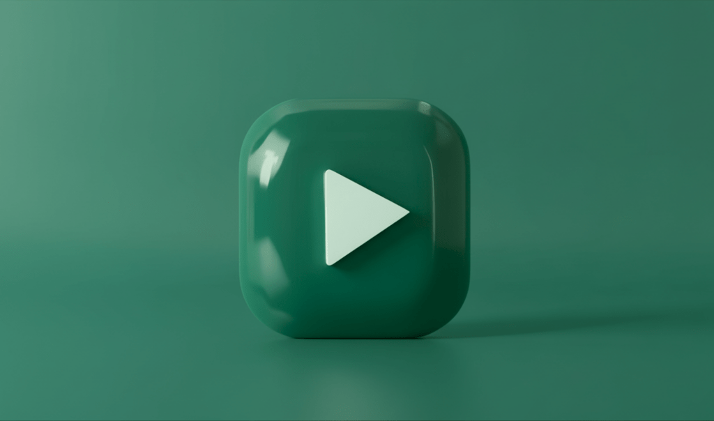 A glossy teal play button with a triangular icon, set against a smooth green background.