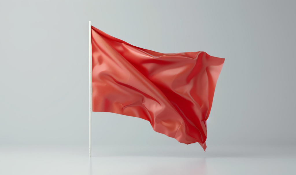 Red flag waving on a white flagpole against a light gray background with soft shadows.