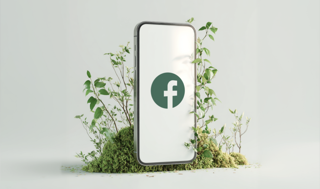Smartphone with a green Facebook logo on screen surrounded by green plants and moss on a white background.