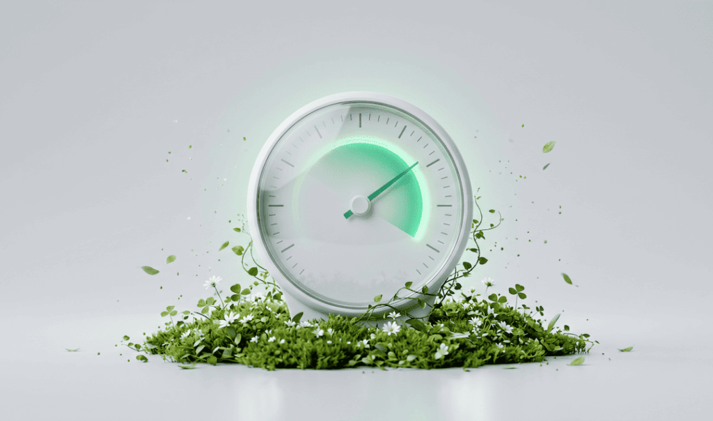 White gauge with a green glowing arc, surrounded by green foliage and white flowers on a light gray background.